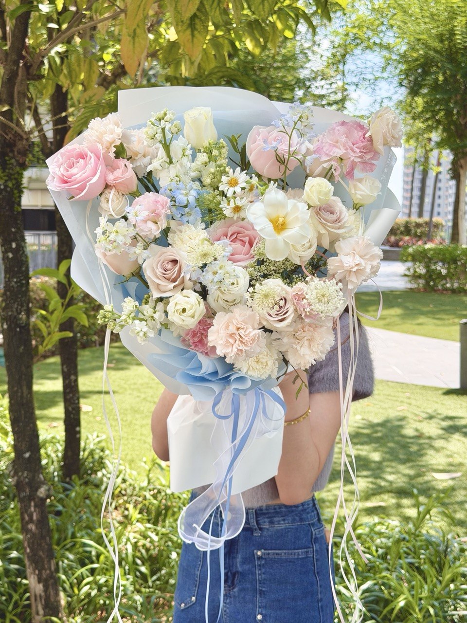 Luxury hand bouquet in blue and pink tones featuring premium pink roses, blue delphinium, white tulip, carnations, and delicate seasonal flowers, available for same-day flower delivery in Kuala Lumpur and Selangor.