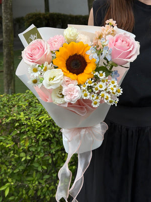 Bright sunflower bouquet with pink roses, white flowers and chamomile wrapped in premium white paper, perfect for graduation flowers, thank you gifts and same day flower delivery Malaysia.