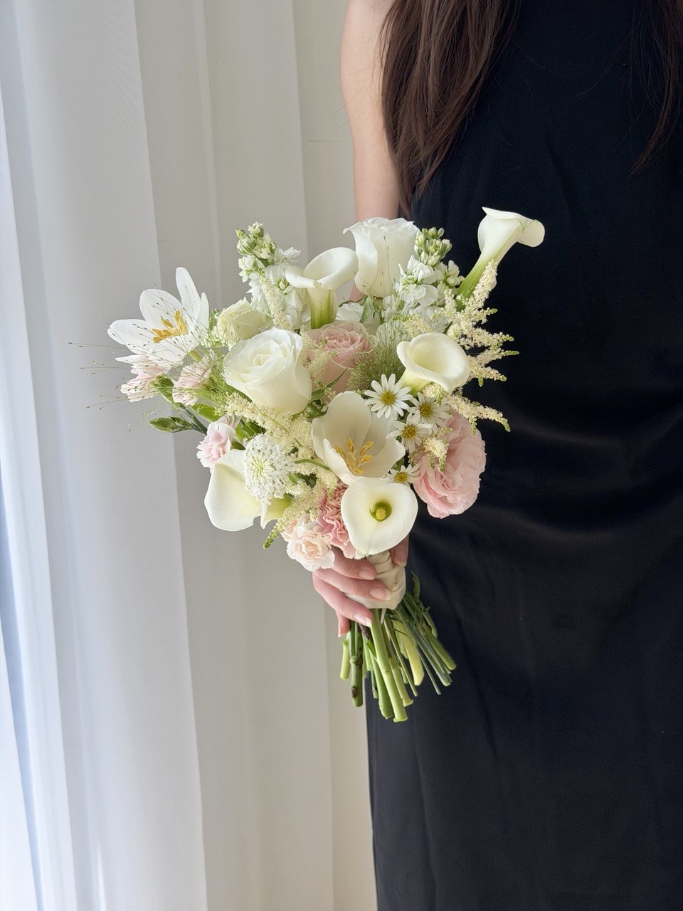 Modern wedding hand bouquet with white calla lily, tulip, astilbe, white roses and soft pink roses for brides, available with same day flower delivery in Kuala Lumpur.