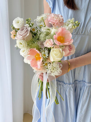 A girl is holding a bouquet of ROM flower consist of tulip, menta rose, white eustoma and other fillers - same day delivery wedding flower at Kuala Lumpur and Selangor.