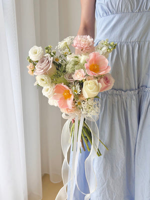 A girl wearing a blue dress is holding a bouquet of ROM flower consist of tulip, menta rose, white eustoma and other fillers - same day delivery wedding flower at Kuala Lumpur and Selangor.