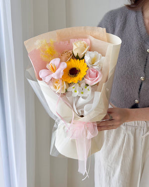 A girl is holding a bouquet of soap flower with sunflower perfect for graduation flower at Subang Jaya.