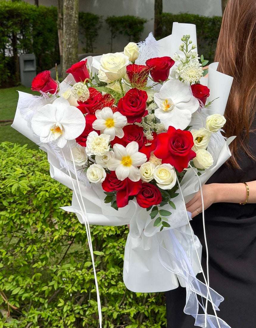 A bouquet of red rose and white rose is help by a girl waring black dress at outdoor at Subang Jaya.