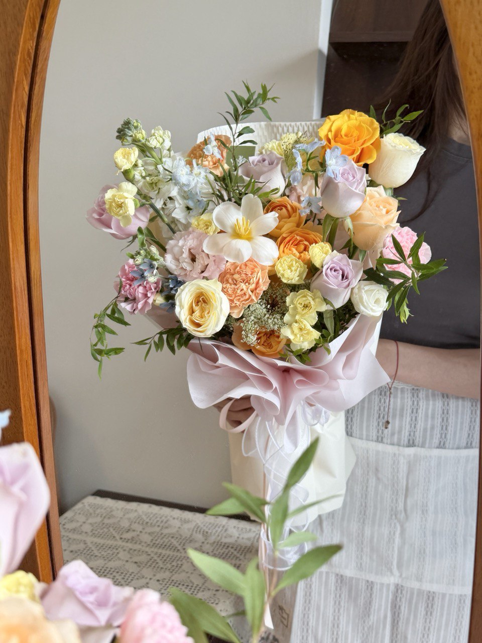 Bouquet of flowers held by a person in front of a mirror in a studio at Kuala Lumpur.
