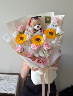 A bouquet of soap flower consist of pink soap flower, soap sunflower, and white soap roses perfect for graduation flower.