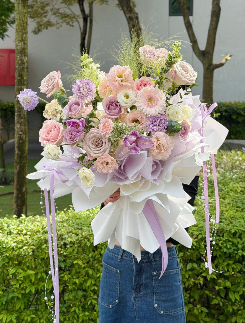 A ballet purple theme bouquet with purple tulip, purple carnation, Apricot Eustoma, Gerbera, Pink rose and green lace flower perfect for birthday and anniversary flower gift idea.