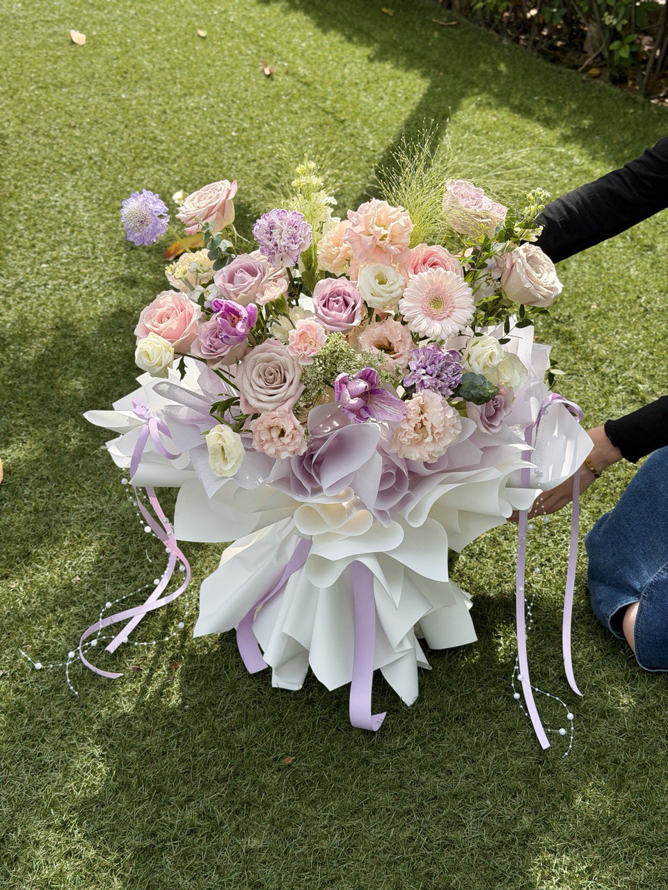 Luxury pastel purple theme floral bouquet featuring lilac roses, pink gerbera, peach carnations and seasonal fillers, perfect for birthday or anniversary gift.