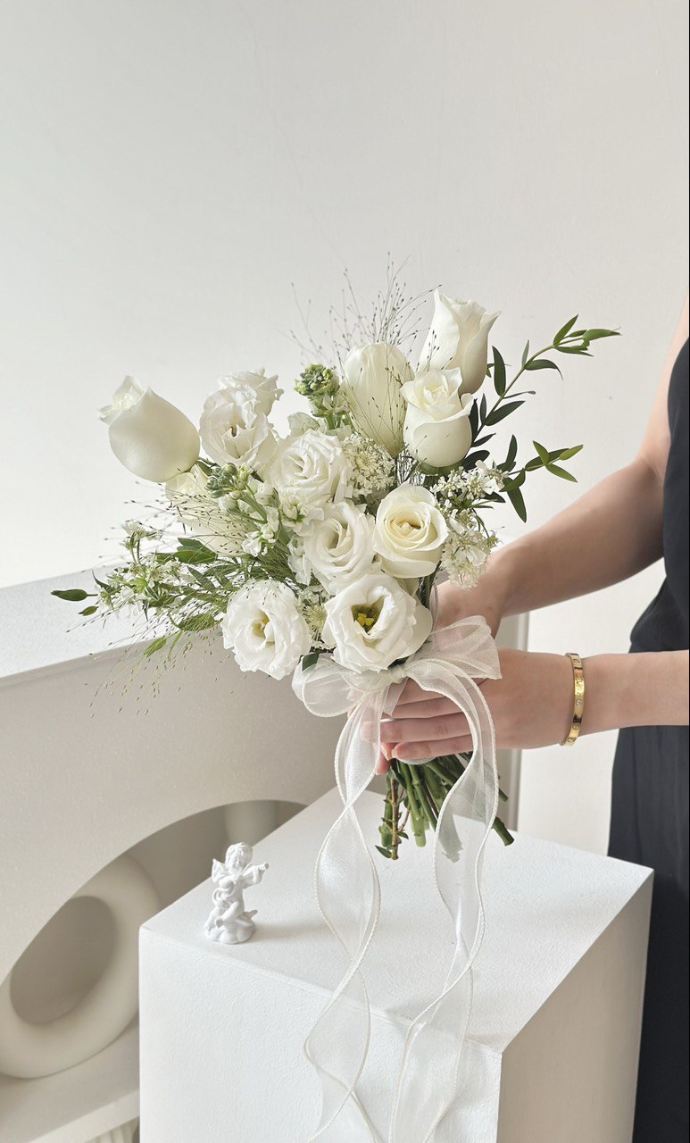 A girl is holding a bouquet of white rose ROM bouquet for her ROM day at Kuala Lumpur.