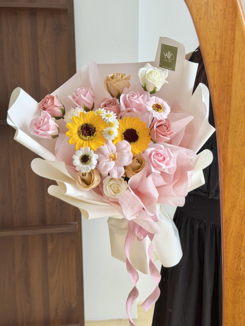 A girl wearing black dress is holding a bouquet of Soap Flower for her graduation - soap flower with sunflower perfect for graduation.