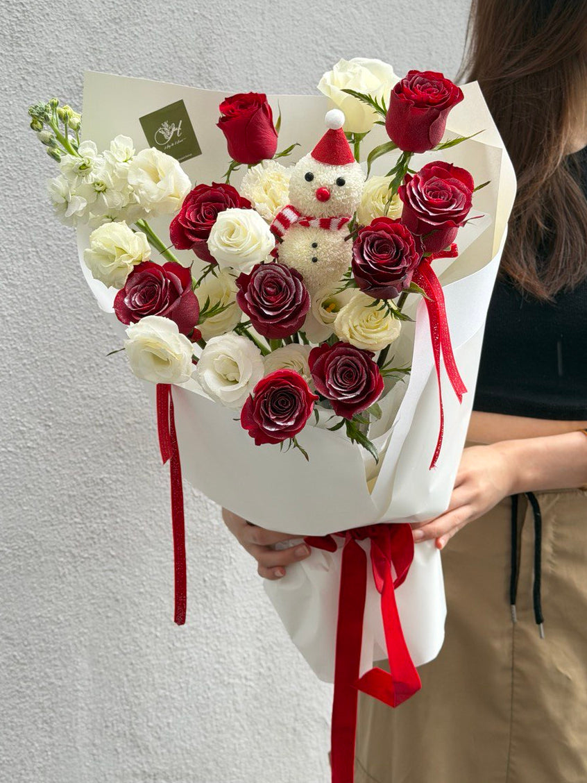 Bouquet of red and white roses with a snow man ping pong, held by a girl against a gray background.