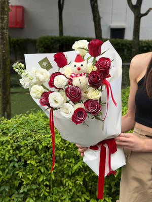 A bouquet of red rose and white eustoma with a snow man figure perfect for Christmas gift at Kuala Lumpur.