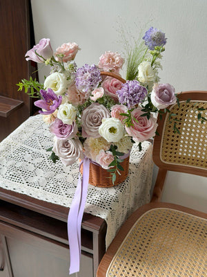 Soft purple and blush flower basket arrangement, perfect as a housewarming gift to celebrate moving into a new home.