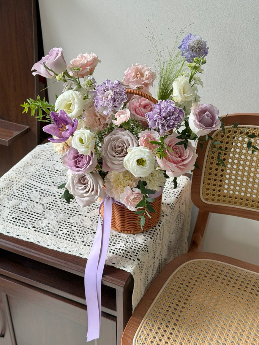 Soft purple and blush flower basket arrangement, perfect as a housewarming gift to celebrate moving into a new home.