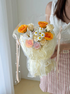 Soap flower bouquet in round wrapping with orange roses, white roses and daisies, ideal for birthdays and anniversaries.