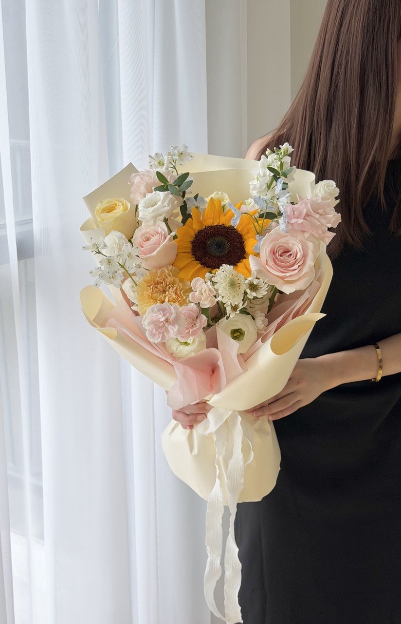 Elegant sunflower flower bouquet featuring blush pink roses, white eustoma, and premium wrapping for graduation bouquet.