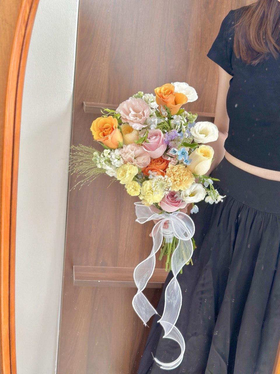 Bright wedding hand bouquet with yellow, orange, and pastel pink roses, accented with carnations and delicate fillers, Malaysia florist design.