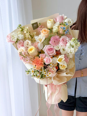 A girl is wearing blue shirt holding a bouquet of L size bouquet perfect for birthday or anniversaries flower.