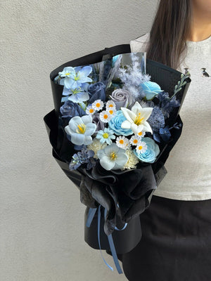 Premium dark blue and black soap flower bouquet with white lily, blue roses, tulips, and daisy flowers for birthdays, anniversaries, and special occasions.