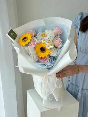 Graduation soap flower bouquet with sunflower, soft pink roses and elegant blue wrapping, same day flower delivery in Bukit Jalil.