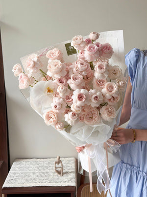 A girl wearing a blue dress holding a bouquet of kiss of fairy rose spray for her birthday celebration at Kuala Lumpur.