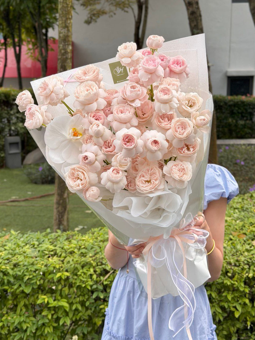 A bouquet of kiss of fairy rose spray with white phalaenopsis prepared by hug and heart florist Kuala Lumpur.