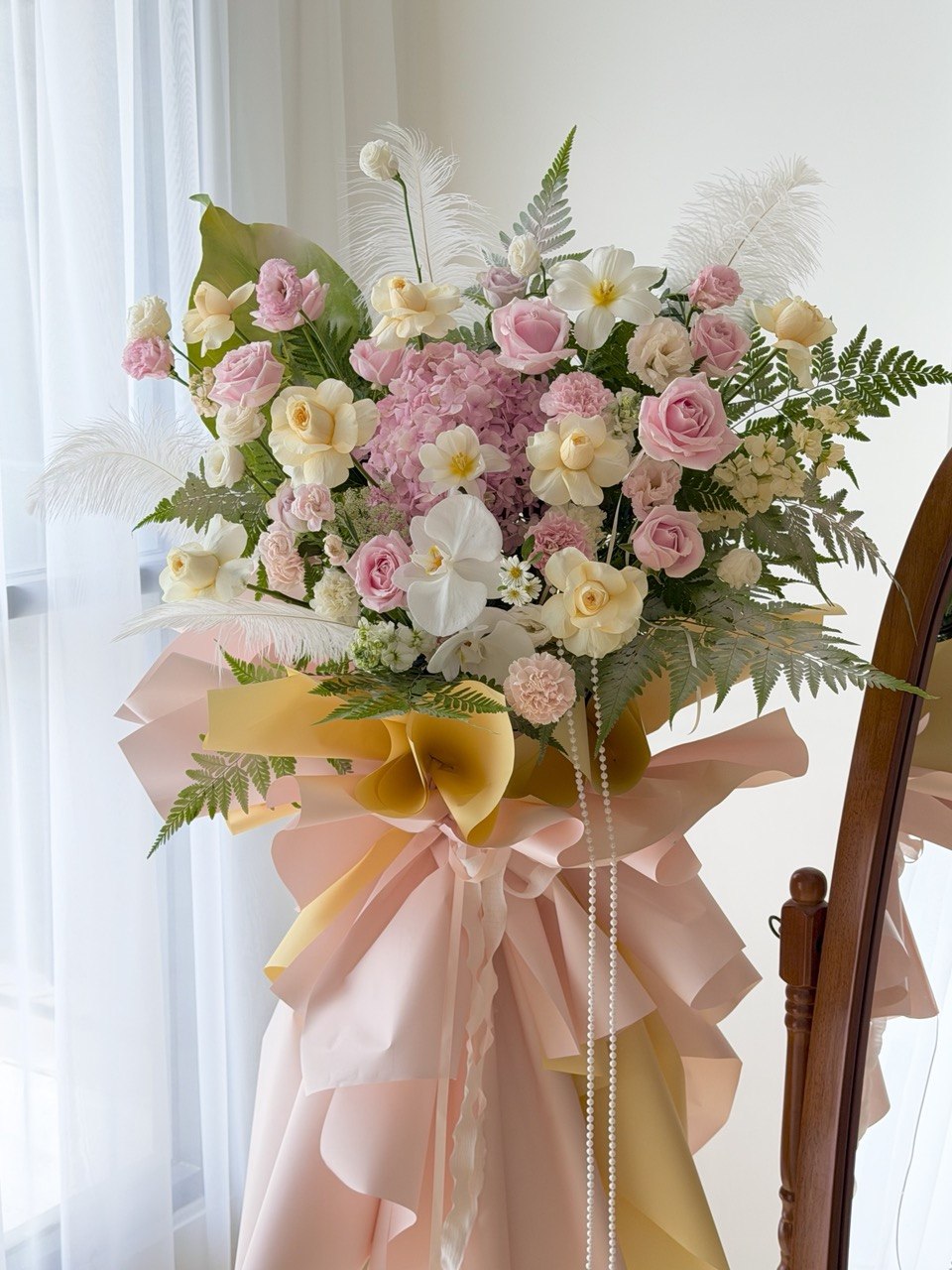 Modern grand opening flower stand designed with blush pink roses, white orchids, hydrangea, carnations and luxury ribbon wrapping for corporate opening gifts in Malaysia.