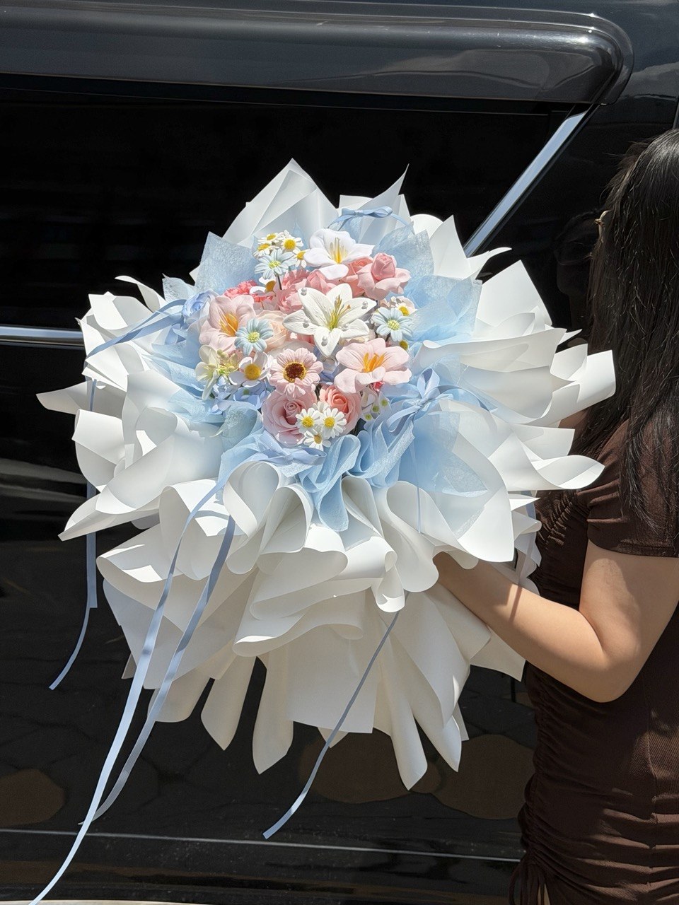 Luxury soap flower bouquet in ballet wrapping style with blue ribbons and pastel blooms, perfect for birthday, anniversary or proposal - prepared by Hug and Heart Florist. 