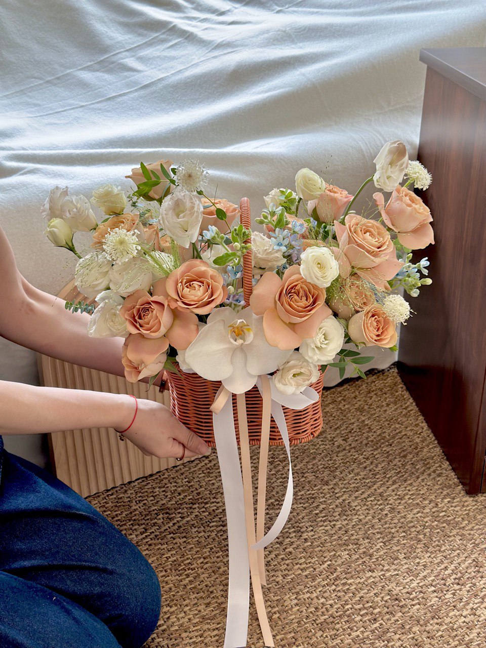 A warm-toned floral basket featuring cappuccino roses and delicate white flowers, suitable for home décor or thoughtful gifting.