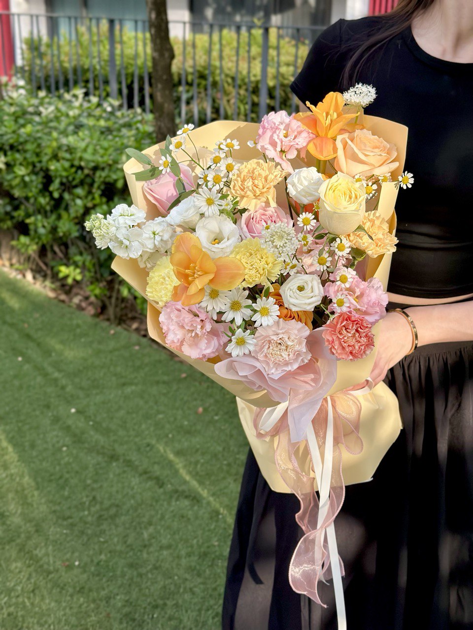 Elegant bouquet wrapped in soft yellow and pink, ideal for celebrations or thoughtful gifts.