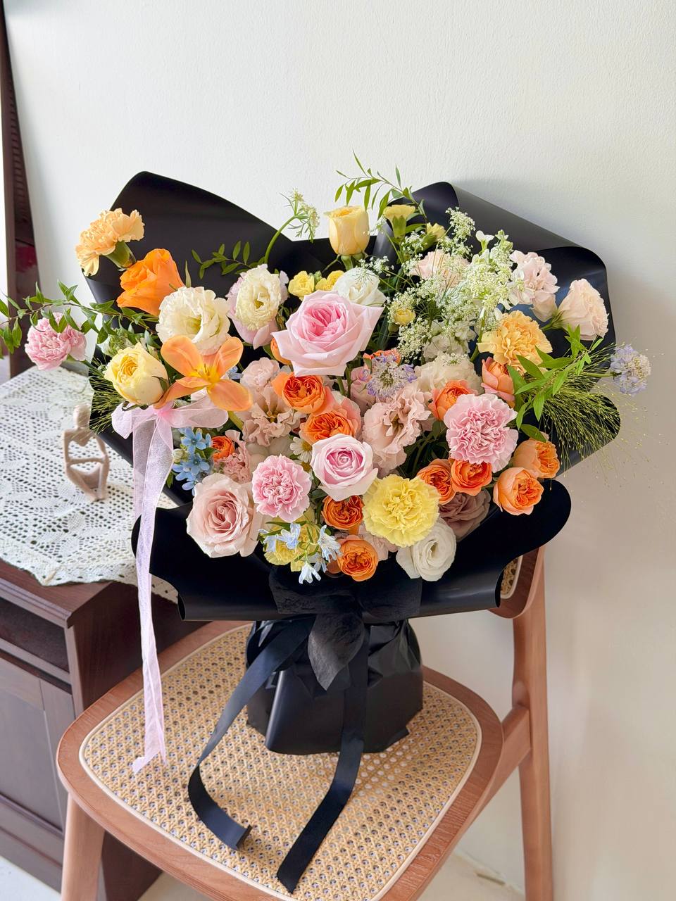 Luxury floral arrangement with orange, yellow, and pink blooms for birthday or anniversary gifts.