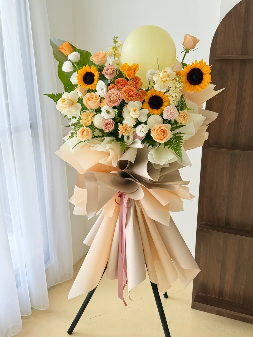 Grand opening flower stand with sunflowers and champagne roses mixed with balloon and filler.