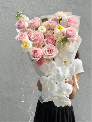 Premium floral arrangement of blush pink roses, white phalaenopsis orchids, and tulips, designed for elegant gifting and sophisticated celebrations.