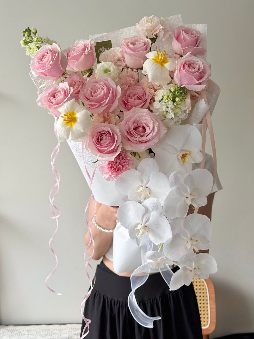 Elegant bouquet featuring soft pink roses, white phalaenopsis orchids, and fresh tulips, beautifully hand-wrapped for romantic occasions, birthdays, and premium flower delivery.