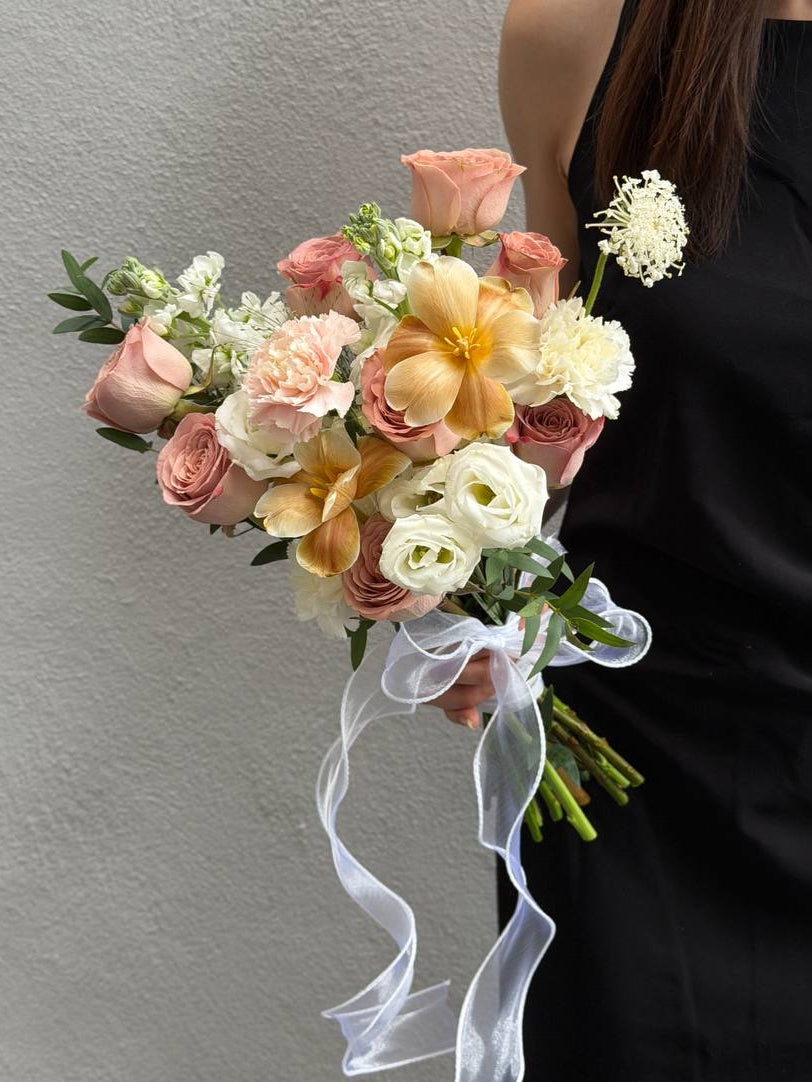 A beige colour dye tulip and cappuccino rose is held by a girl wearing a black dress for ROM.