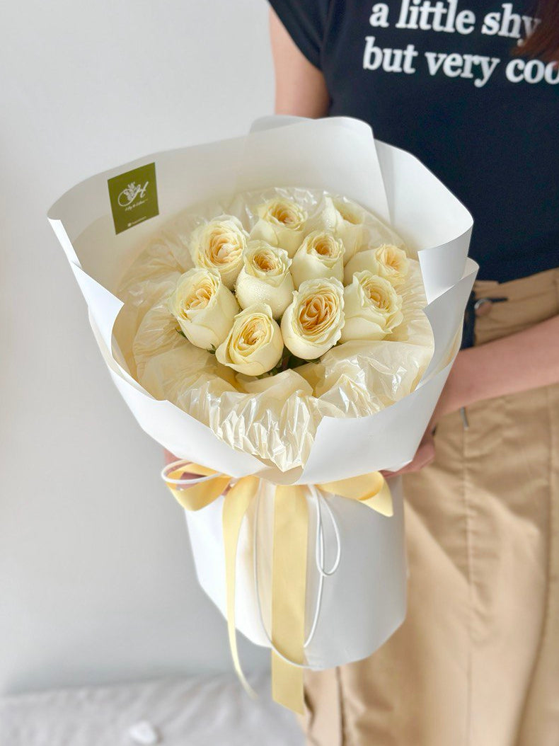 A girl is holding a round bouquet of buttercup roses - same day delivery flower Kuala Lumpur and Selangor, prepared by hug and heart florist subang jaya.