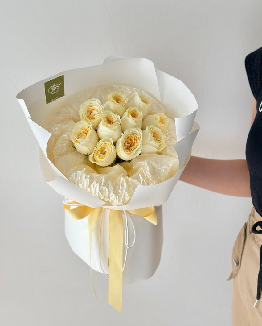A girl is holding a round bouquet of buttercup roses - same day delivery flower Kuala Lumpur and Selangor, prepared by hug and heart florist subang jaya.