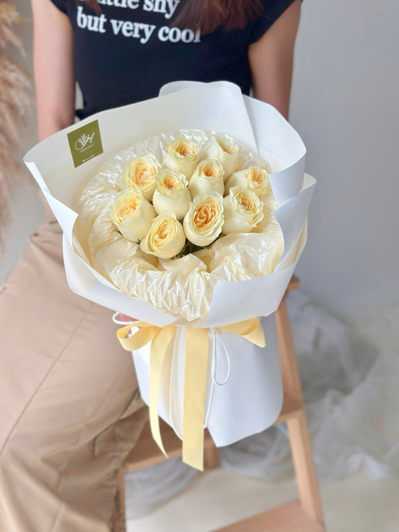 A girl is holding a round bouquet of buttercup roses - same day delivery flower Kuala Lumpur and Selangor, prepared by hug and heart florist subang jaya.
